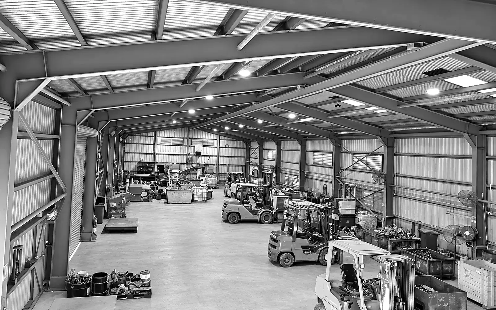 Inside CMR Recycling's shed in Mackay, forklifts and sorted scrap under a high steel roof