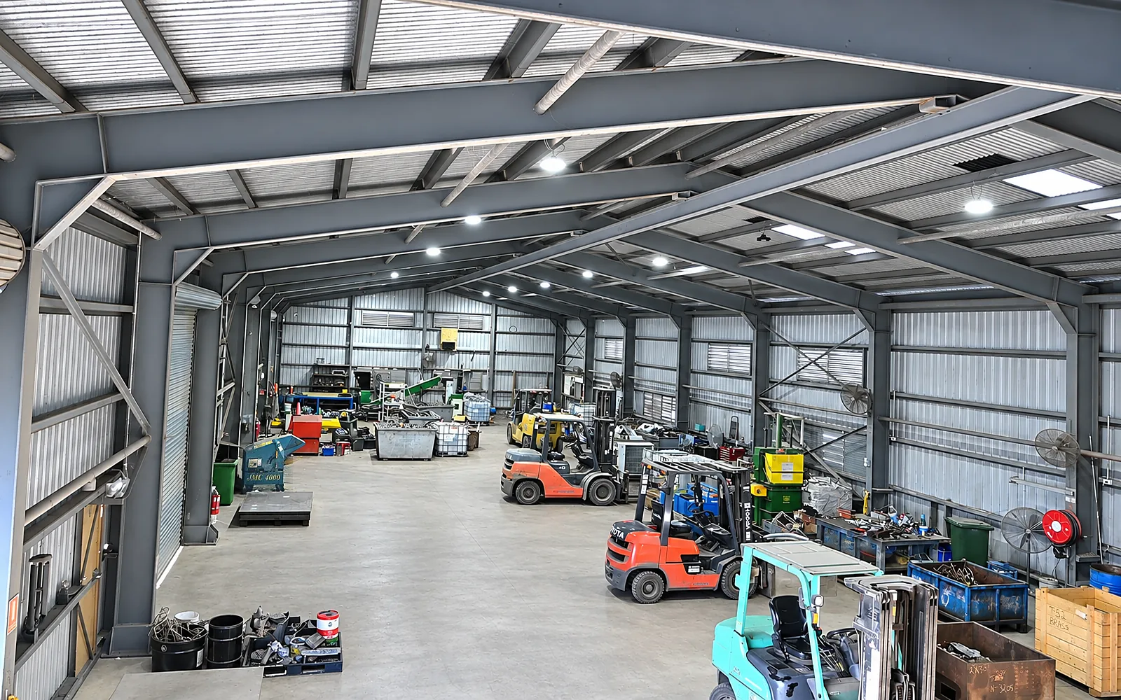 Inside CMR Recycling's processing shed in Mackay, sorted scrap metal in bins across the concrete floor